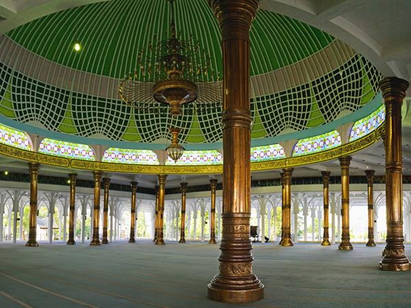 Interior of Al Falah Mosque with green dome and timber columns